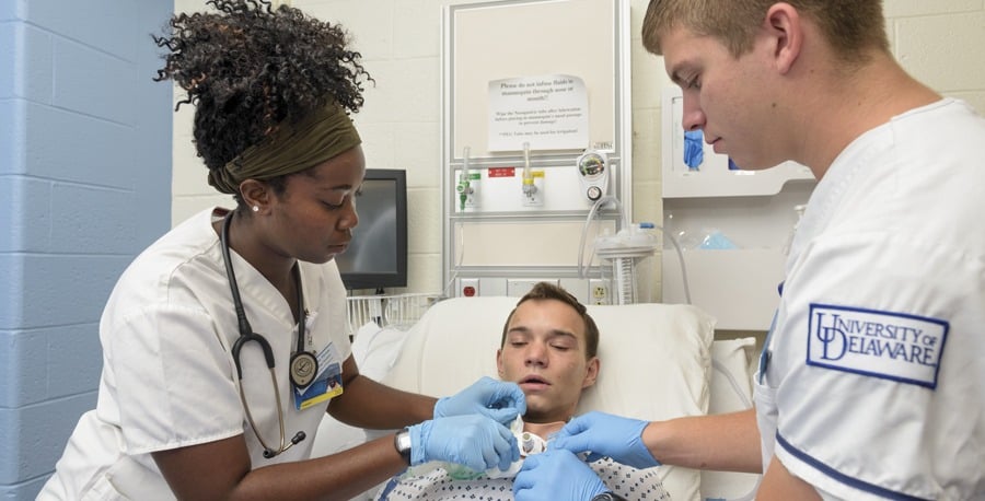 Nursing students Jerelene Thorpe (left) and Cory Haaf (right) were among the first to practice tracheostomy care in a unique way in 2016—using the lifelike Avtrach device, worn by volunteer “patient” Robert Tilley (center).