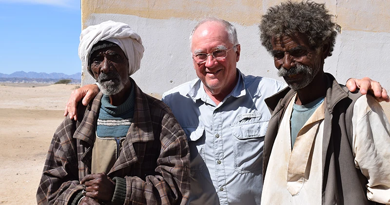 Sidebotham poses with dig worker Mohammed Eid and his father at Berenike in 2024.